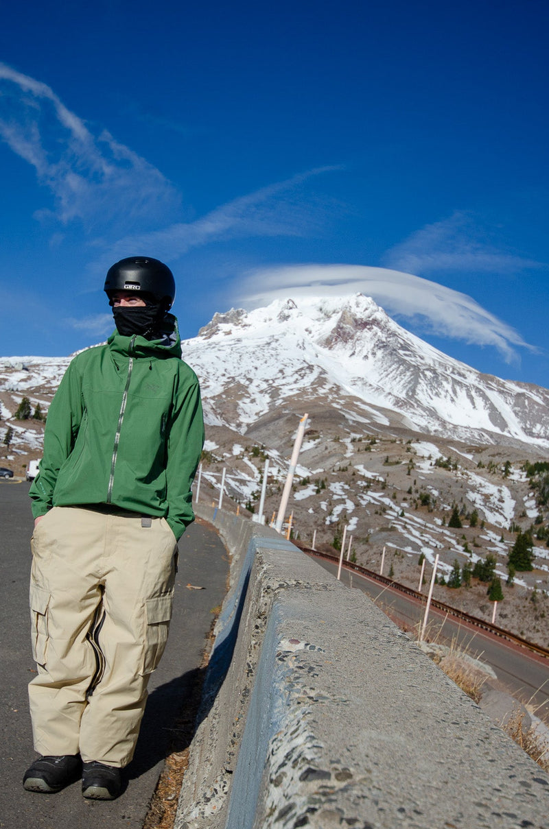 Person standing on a road with a snow-capped mountain in the background